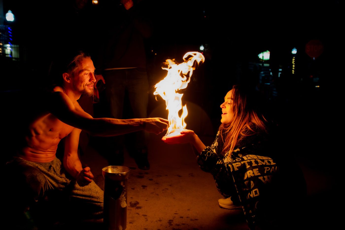 Tyler placing a burning fire bubble into a smiling guest's open palm